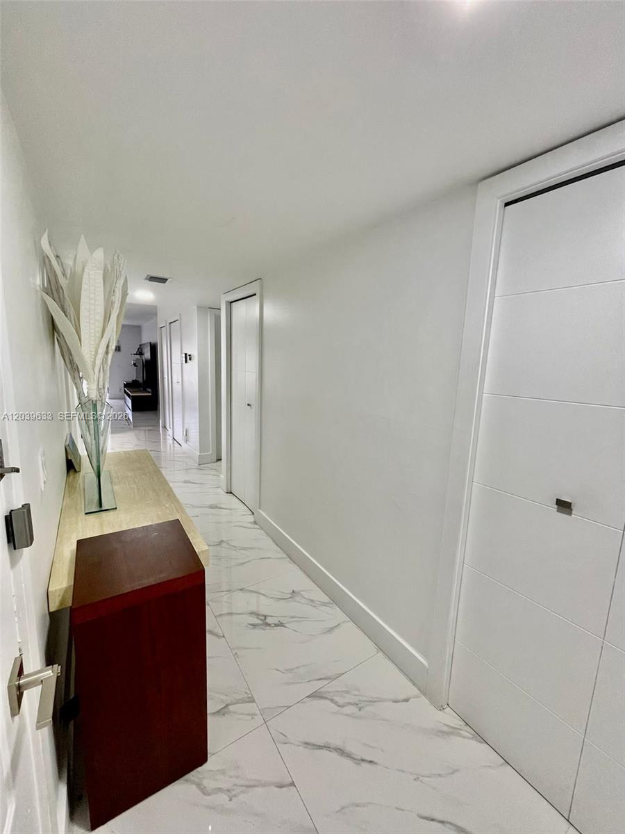 A hallway features white walls, marble-patterned tile flooring, and several closed white doors — 16461 Blatt Blvd # 103, Weston FL 33326, WESTON, FL