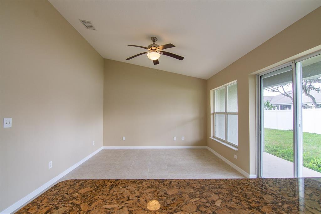 An empty bedroom features gray walls, beige carpeting, a window, and a ceiling fan — 402 BRIDGEWATER COURT, KISSIMMEE, FL