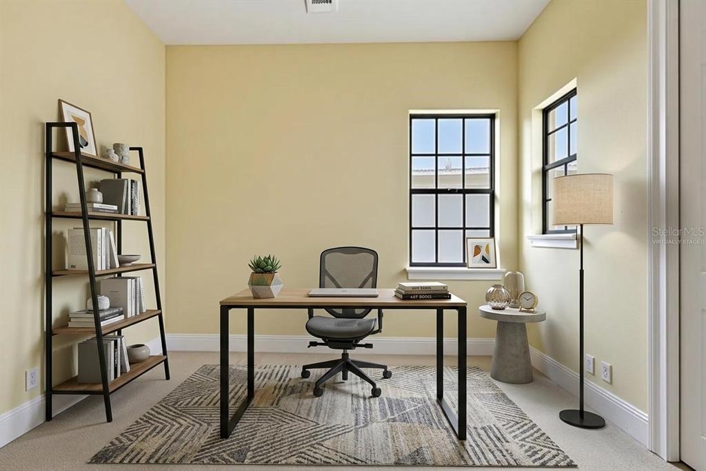 A home office with a desk, chair, bookshelf, and rug in a room with yellow walls — 877 DESERT MOUNTAIN COURT, KISSIMMEE, FL