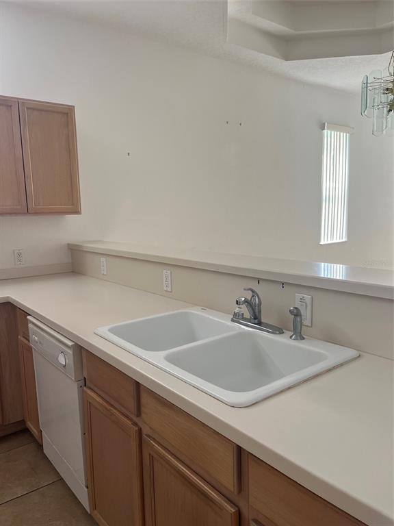 A kitchen features light-colored countertops, a double-basin sink, and light wood cabinetry — 7211 CLEOPATRA DRIVE, LAND O LAKES, FL