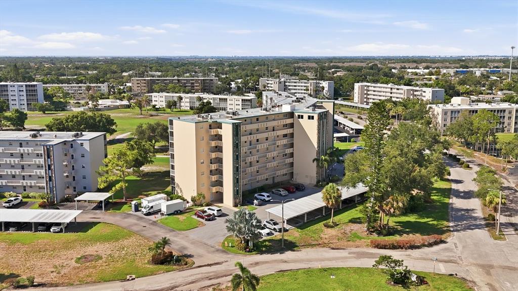 An aerial view shows a multi-story apartment building surrounded by parking lots and green space — 4040 IRONWOOD CIRCLE UNIT 304F, BRADENTON, FL