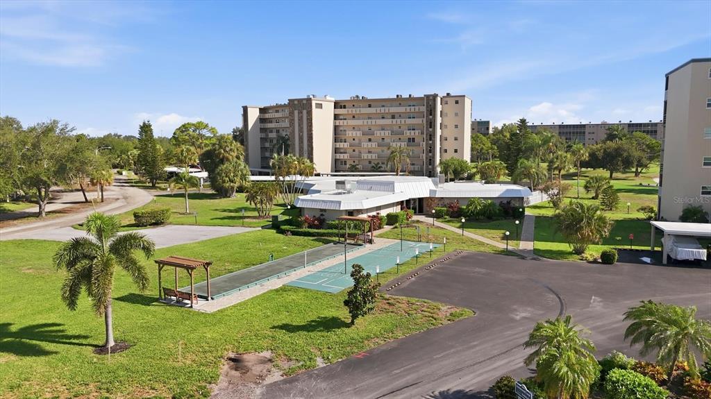An aerial view shows a multi-story apartment building, a clubhouse, and outdoor shuffleboard courts — 4040 IRONWOOD CIRCLE UNIT 304F, BRADENTON, FL