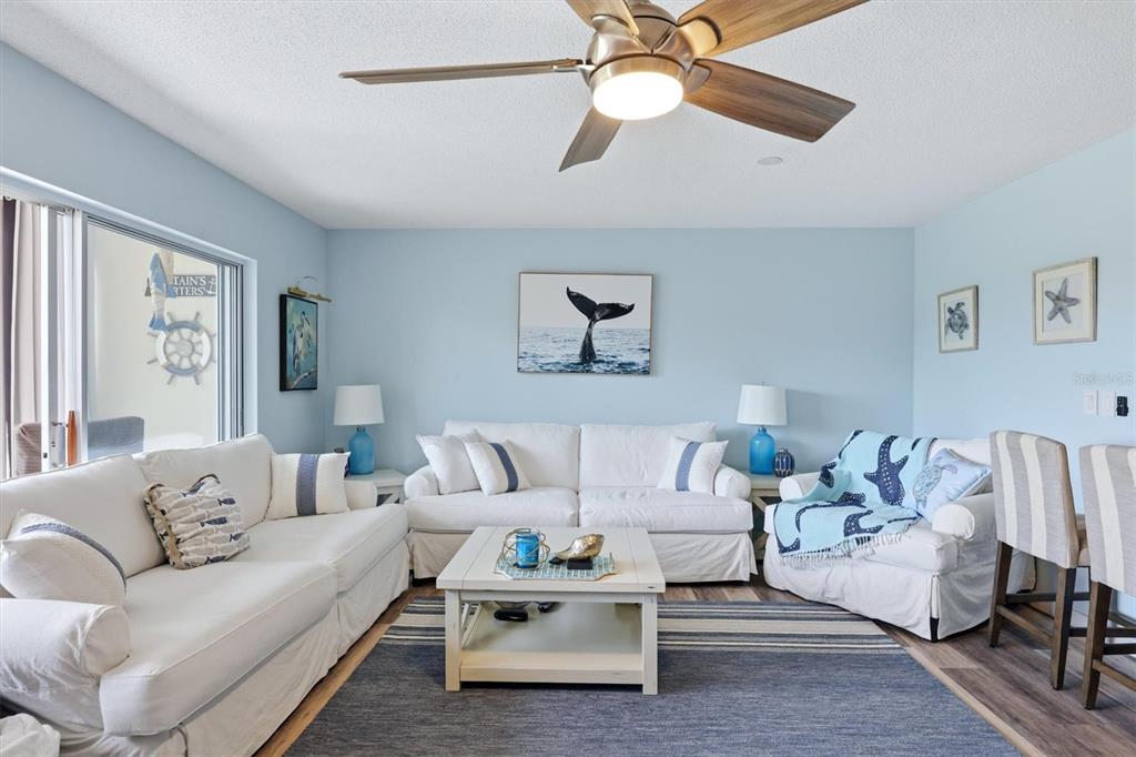 A coastal-themed living room features white sofas, a coffee table, and a ceiling fan — 4040 IRONWOOD CIRCLE UNIT 304F, BRADENTON, FL