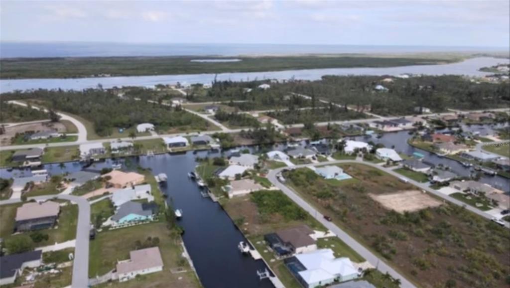 An aerial view of a coastal residential neighborhood featuring houses along a network of canals — 15442 MCCOMB CIRCLE, PORT CHARLOTTE, FL