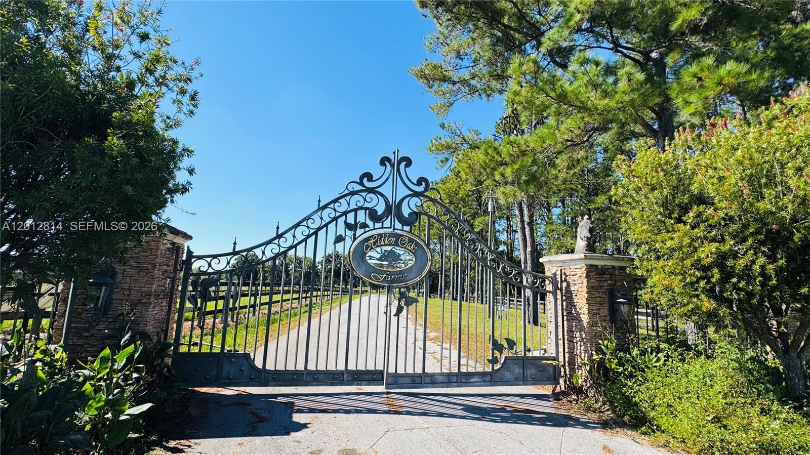 A decorative metal gate marks the entrance to a property named Hidden Oaks Farms — 14500 N HWY 27, Ocala FL 34482, OCALA, FL