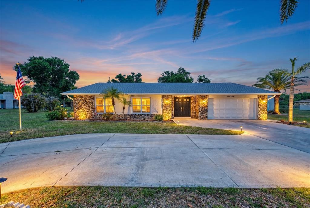 A single-story house with a stone facade, a two-car garage, and a concrete driveway — 1620 MISSION VALLEY BOULEVARD, NOKOMIS, FL