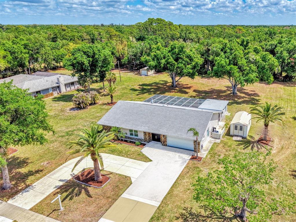 An aerial view shows a single-story house with a screened pool and detached shed — 1620 MISSION VALLEY BOULEVARD, NOKOMIS, FL