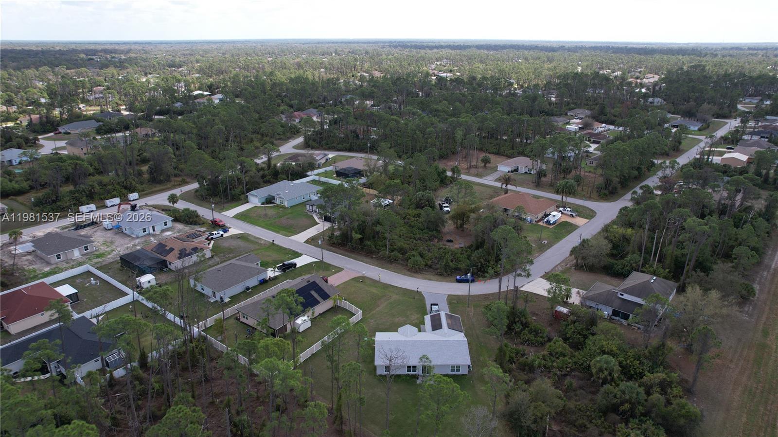 An aerial view shows several single-family homes surrounded by trees and paved roads — 0 GANTRY RD, North Port FL 34288, NORTH PORT, FL