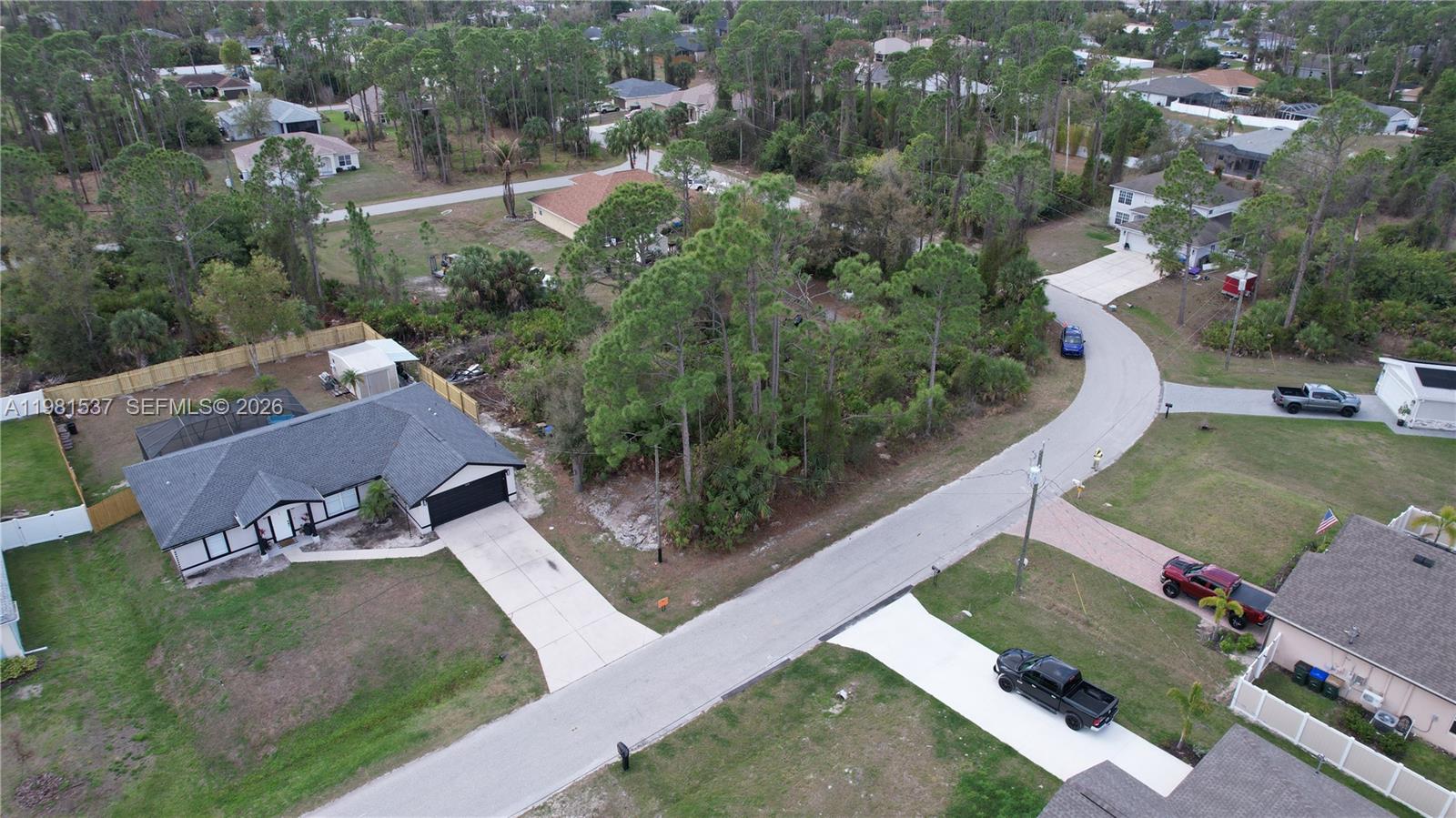An aerial view shows a residential street with houses, driveways, and a wooded vacant lot — 0 GANTRY RD, North Port FL 34288, NORTH PORT, FL