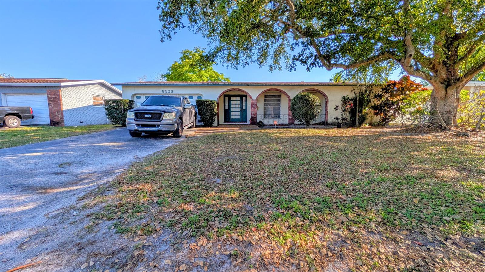 A single-story house with a driveway, a parked truck, and a large tree in front — 8528 Windsor Drive, Miramar FL 33025, MIRAMAR, FL