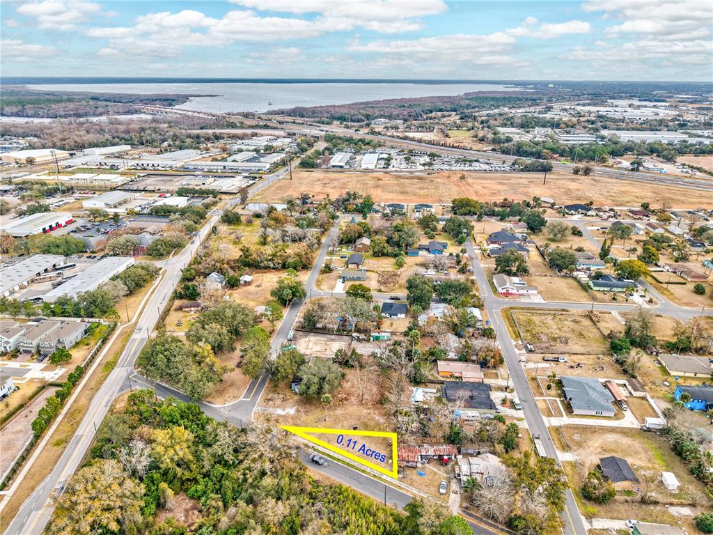 An aerial view shows a small, triangular vacant lot highlighted in yellow within a neighborhood — MCKAY STREET, SANFORD, FL