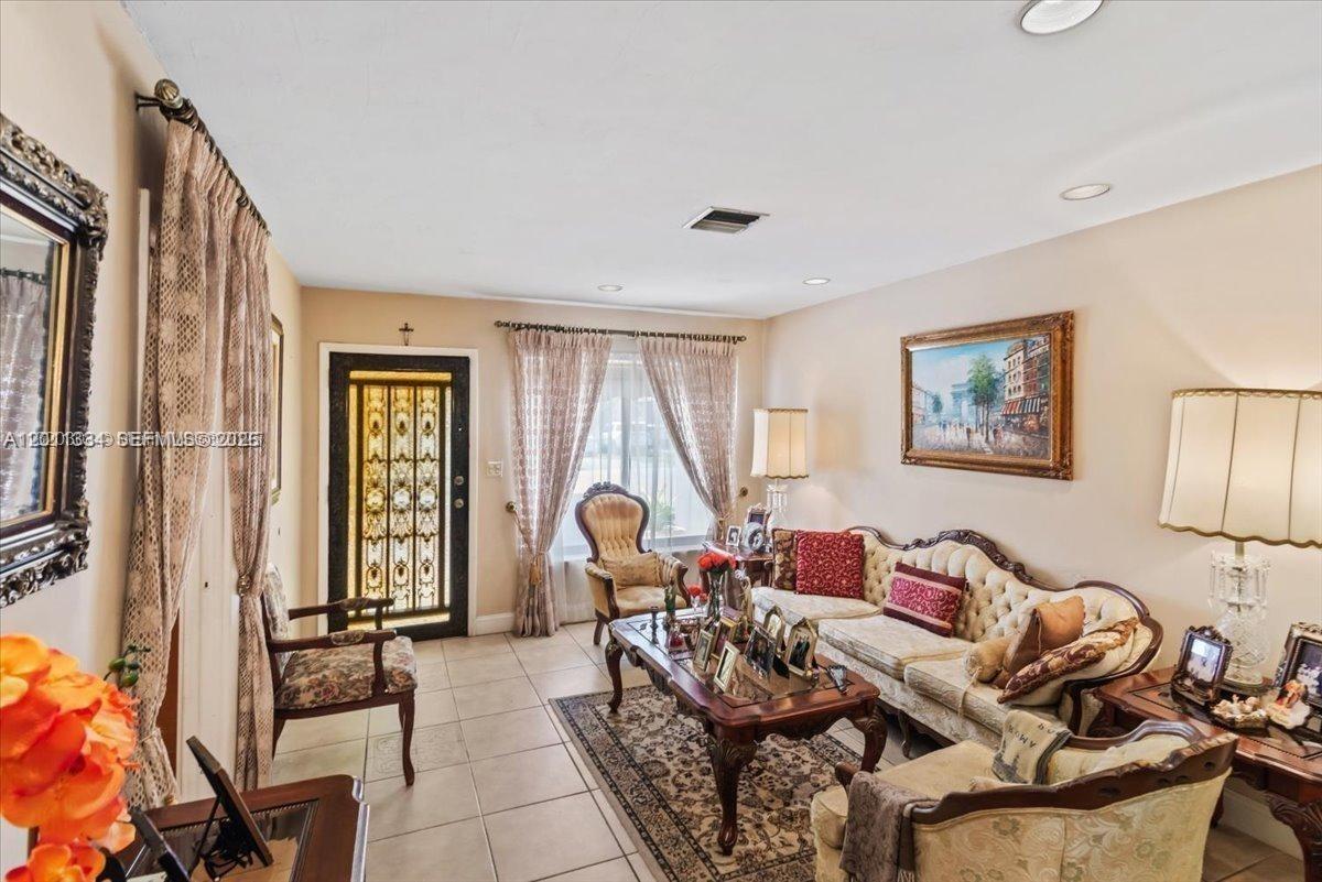A formal living room features tiled floors, ornate furniture, a patterned rug, and a decorative door — 6385 SW 25th St, Miami FL 33155, MIAMI, FL