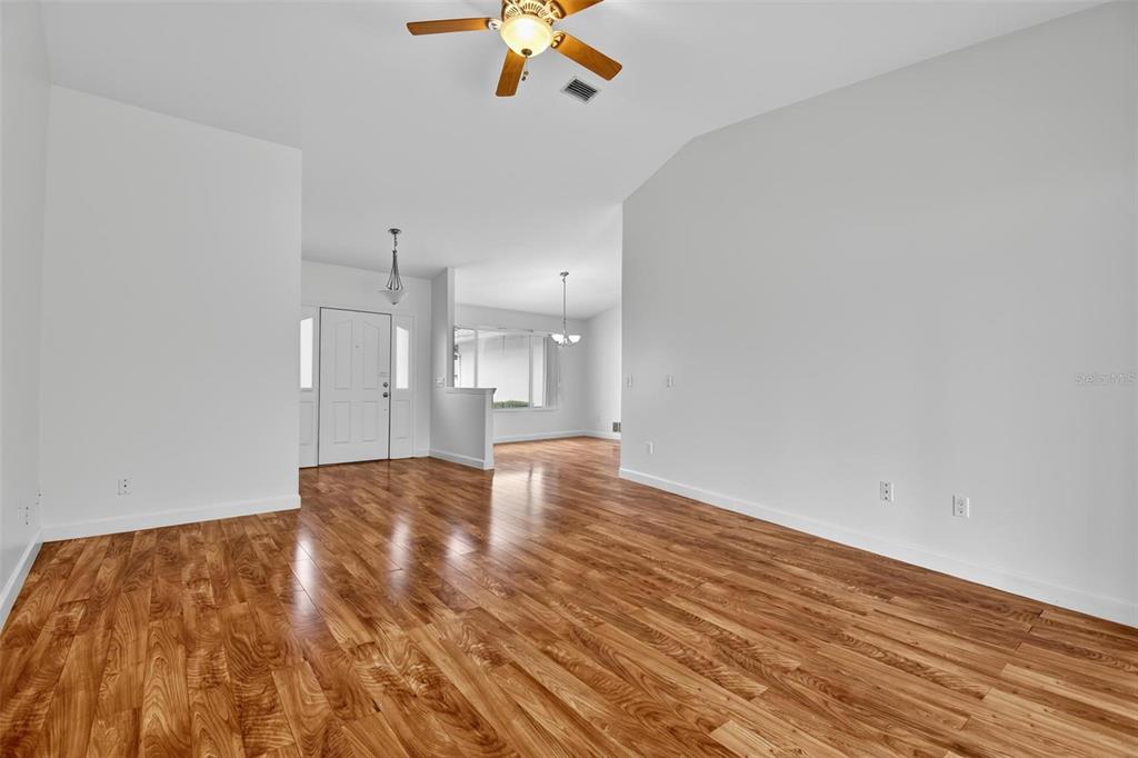An empty living room features light gray walls, wood-look flooring, and a ceiling fan — 231 WELLINGTON DRIVE, PALM COAST, FL