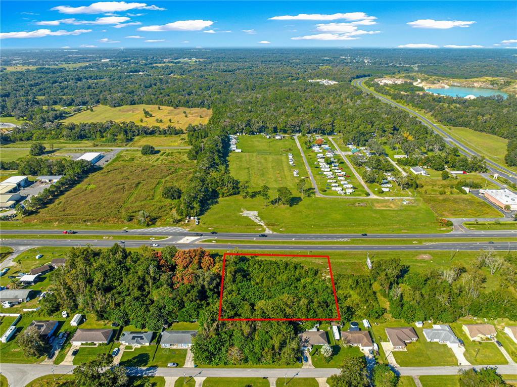 An aerial view shows a rectangular wooded lot outlined in red near a highway — 0 N US HWY 441, OCALA, FL