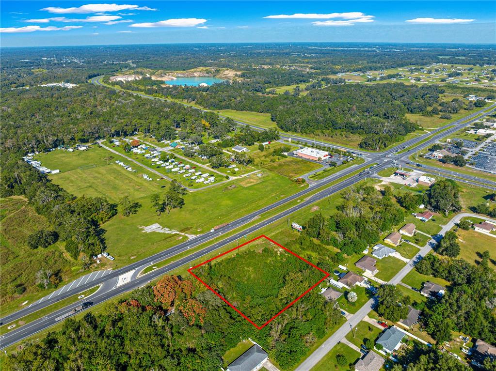 An aerial view shows a vacant, rectangular lot outlined in red next to a highway — 0 N US HWY 441, OCALA, FL