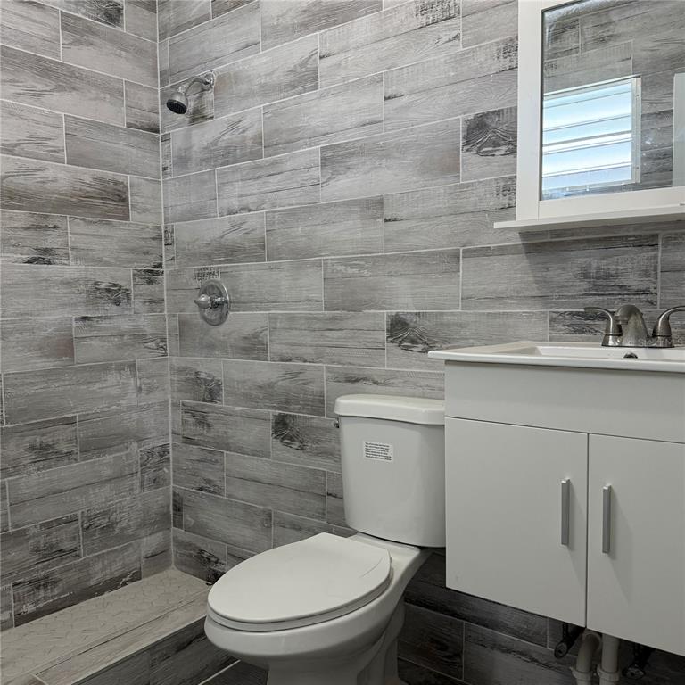 A bathroom features gray wood-look wall tiles, a white vanity, and a toilet — 143 JARDINES DE COUNTRY CLUB Apt 2, CAROLINA, PR