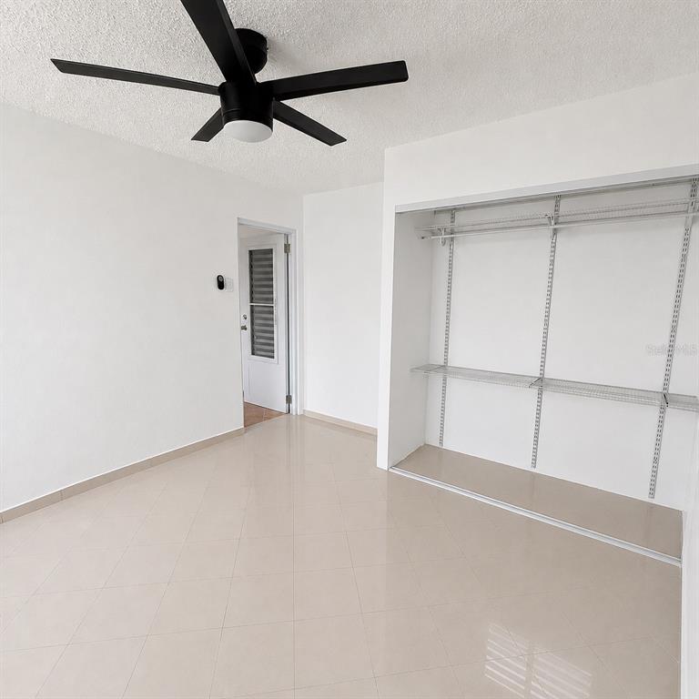 A room with light tile flooring, a ceiling fan, and an open closet with shelving — 143 JARDINES DE COUNTRY CLUB Apt 2, CAROLINA, PR
