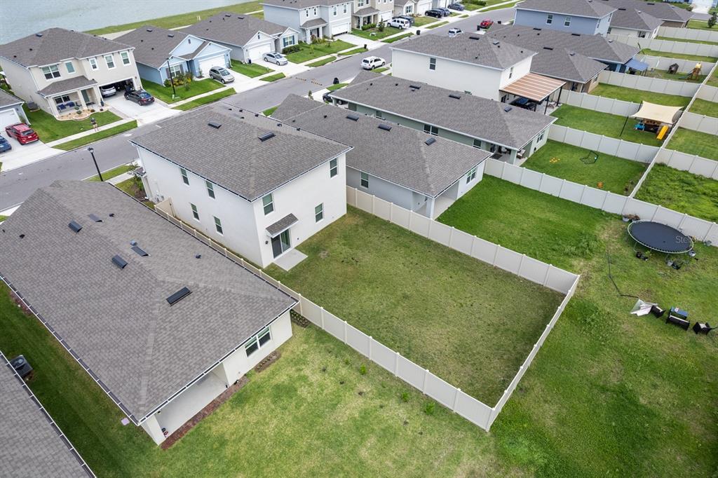 An aerial view shows several suburban houses with fenced backyards and a trampoline — 3524 SUNGROVE CIRCLE, SANFORD, FL
