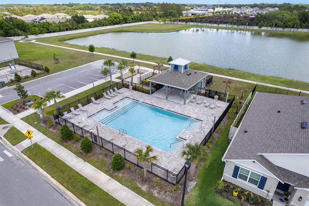 An aerial view shows a community swimming pool and clubhouse next to a large pond — 3524 SUNGROVE CIRCLE, SANFORD, FL