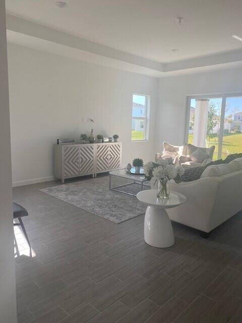 A living room features light-colored walls, tile flooring, a patterned cabinet, and a white sofa — 1121 Haywagon Trail, Loxahatchee FL 33470, LOXAHATCHEE, FL