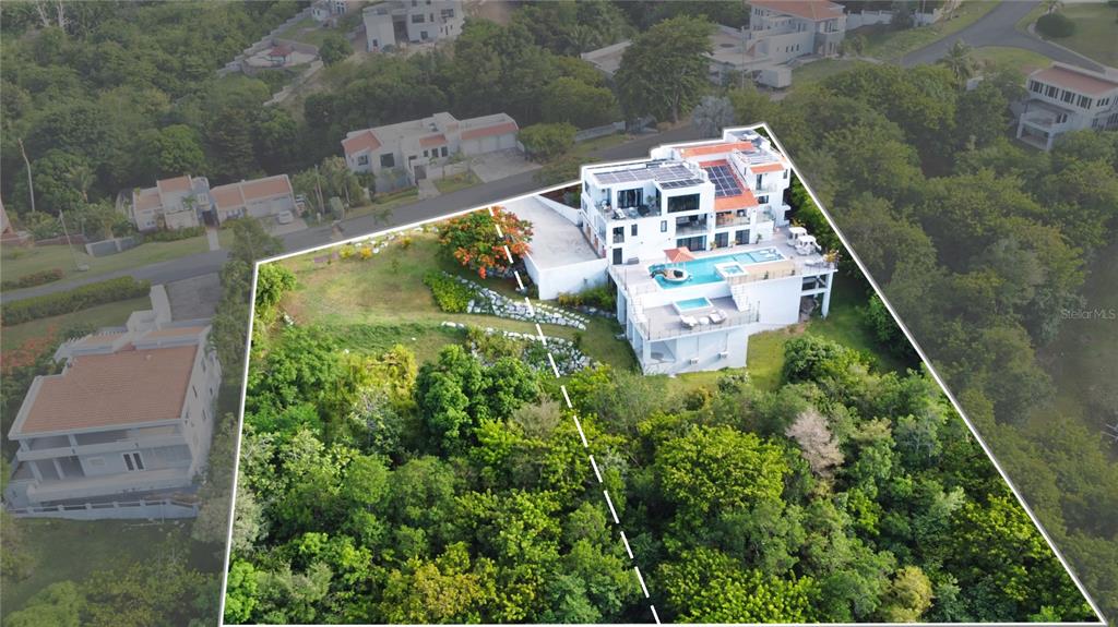 An aerial view shows a modern multi-story house with a pool and solar panels — 13-14 PORT ROAD, HUMACAO, PR