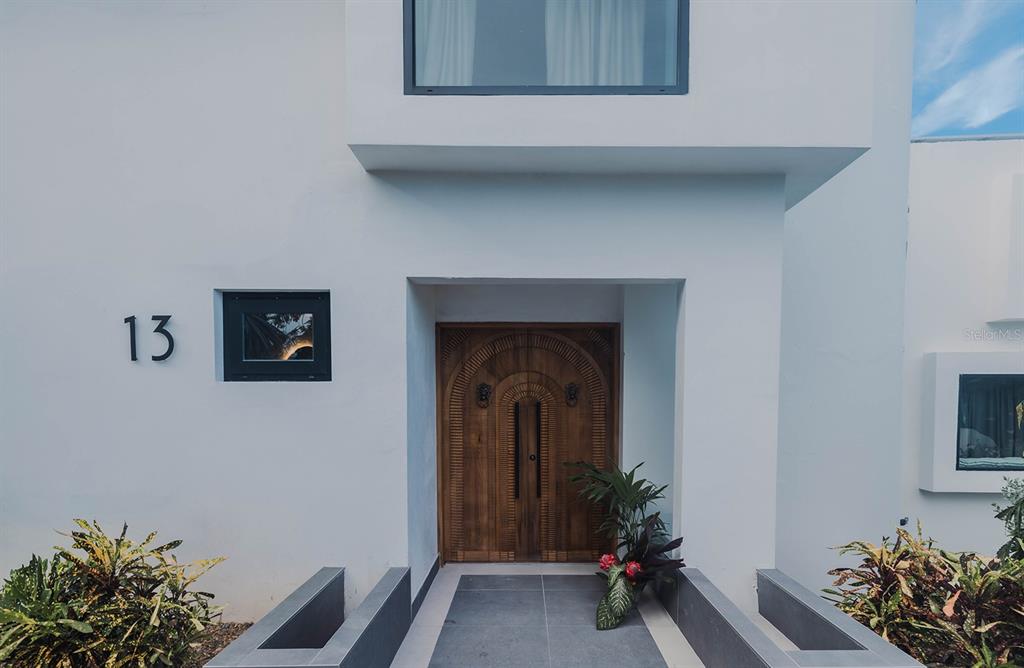A modern white house exterior features a carved wooden double door and the number thirteen — 13-14 PORT ROAD, HUMACAO, PR