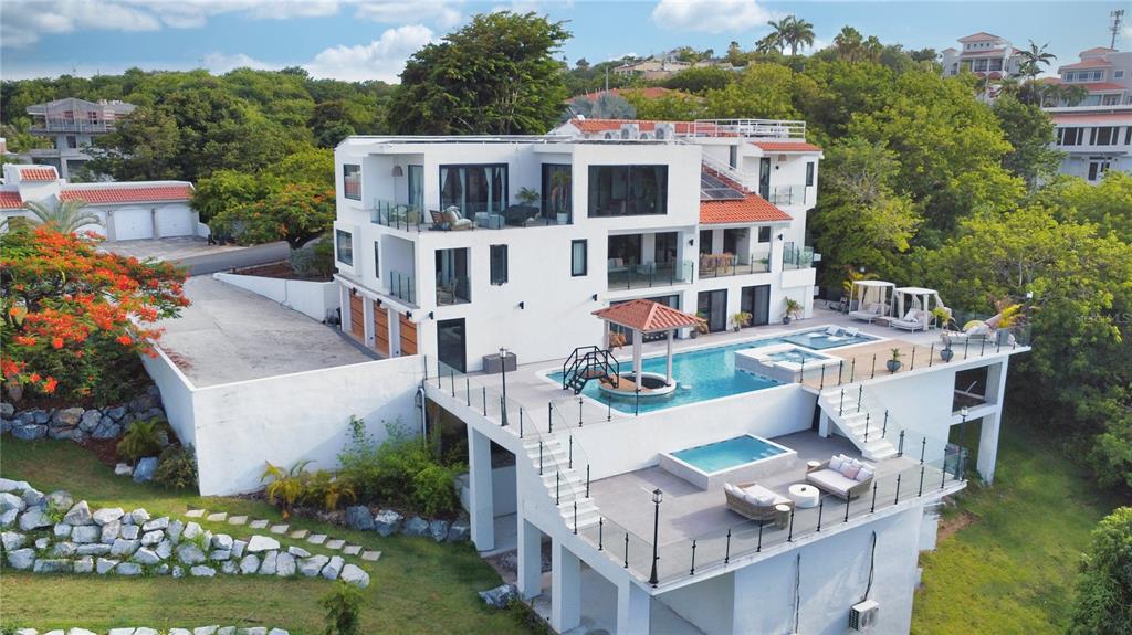 An aerial view of a multi-story white house featuring a tiered pool and patio area — 13-14 PORT ROAD, HUMACAO, PR