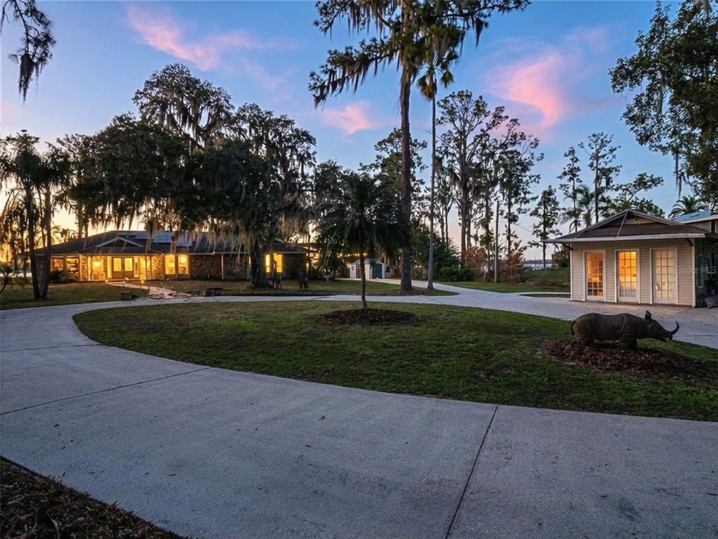 A circular driveway leads to a house and a detached garage with a rhino statue — 14051 MARINE COURT, ORLANDO, FL