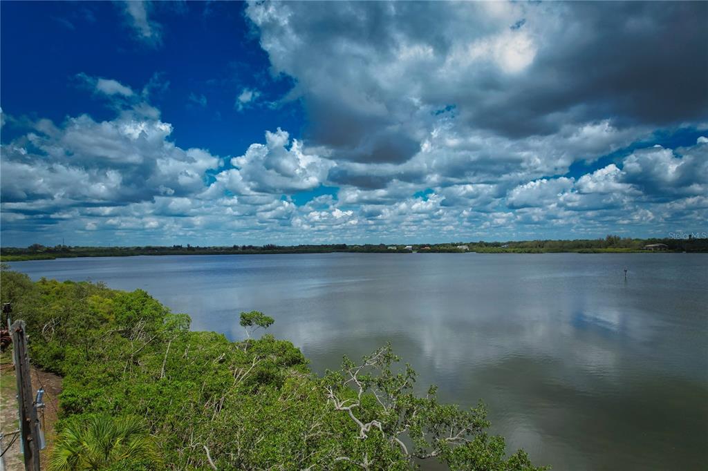 A view of a large body of water bordered by dense green mangroves under a cloudy sky — 160 BAYSHORE DRIVE, TERRA CEIA, FL