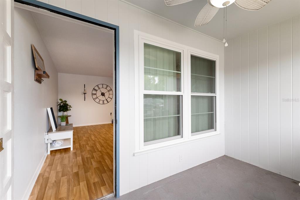 A view from a covered porch looking through a doorway into a room with wood flooring — 4444 SWIFT ROAD UNIT 4, SARASOTA, FL