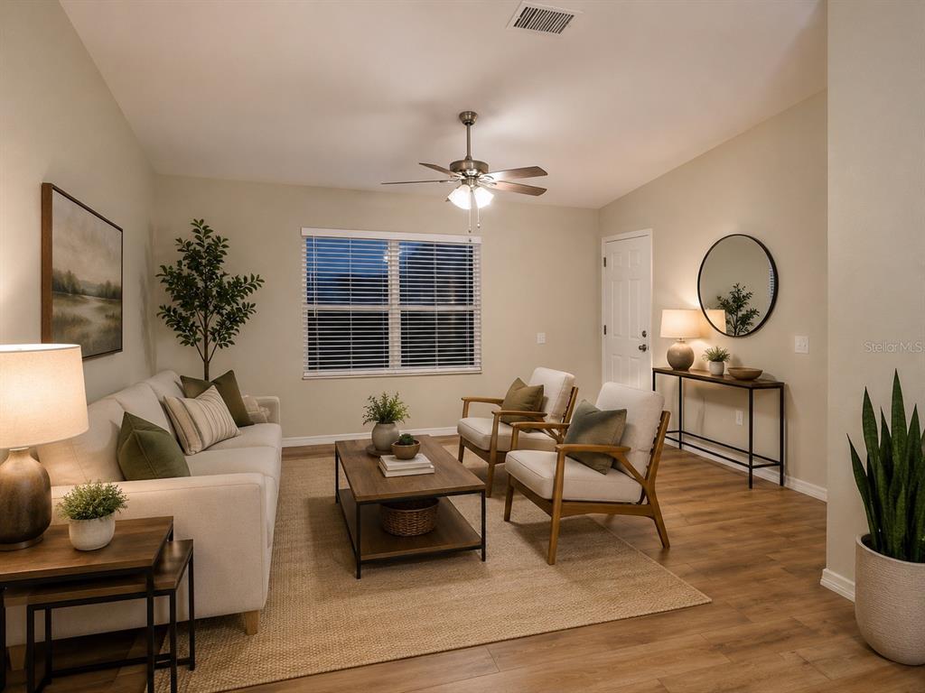 A living room features a sofa, two armchairs, a coffee table, and wood-look flooring — 8577 NE 157TH COURT, SILVER SPRINGS, FL