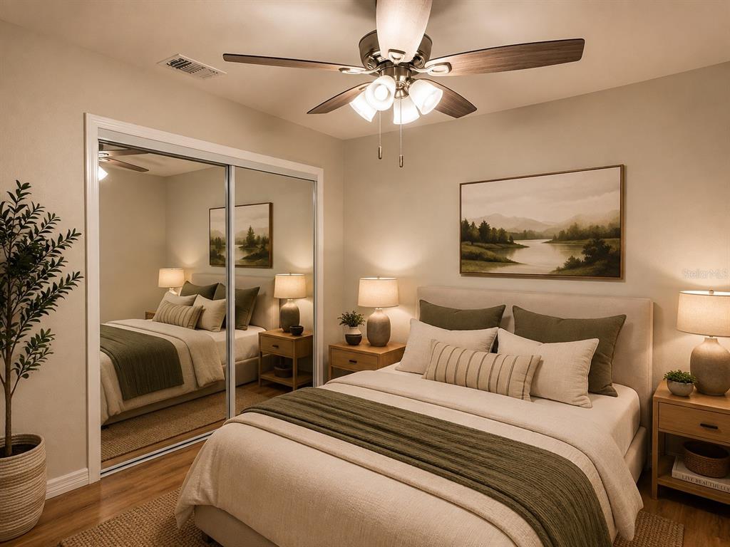 A bedroom features a bed with neutral bedding, a mirrored closet, and a ceiling fan — 8577 NE 157TH COURT, SILVER SPRINGS, FL