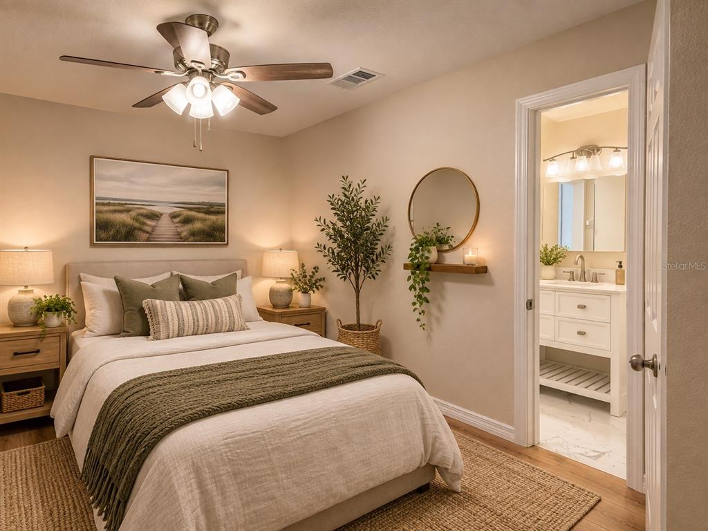 A bedroom with a bed, ceiling fan, and an attached bathroom with a white vanity — 8577 NE 157TH COURT, SILVER SPRINGS, FL