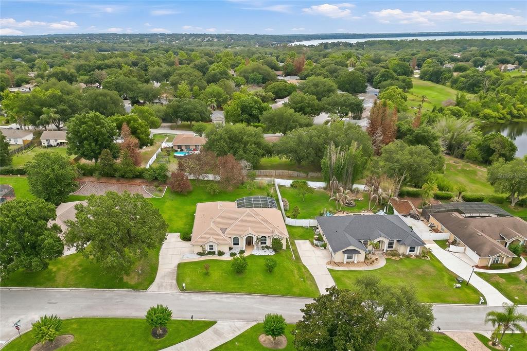 An aerial view shows two suburban houses with swimming pools and large, grassy backyards — 10708 BELO HORIZONTE AVENUE, CLERMONT, FL
