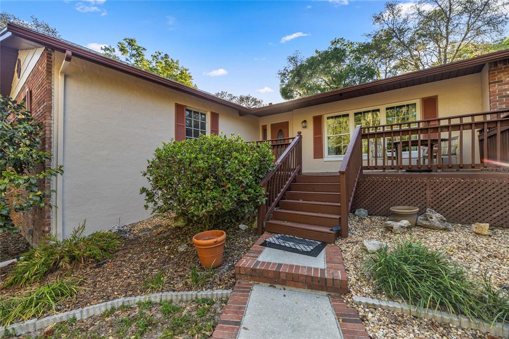 A single-story house with a brick exterior, a wooden deck, and a front staircase — 20949 SW 81ST LOOP, DUNNELLON, FL