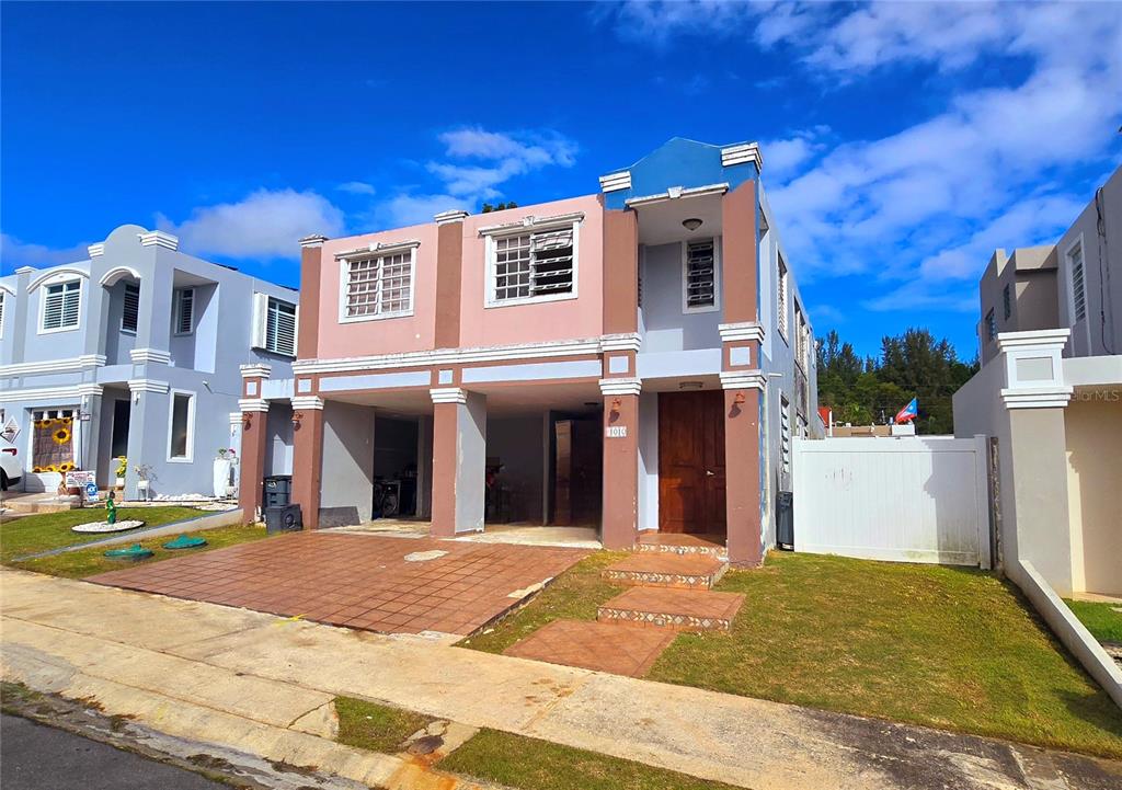 A two-story house with a brown and blue exterior, a carport, and a front lawn — Italia URB. PLAZA DE LA FUENTE UNIT 1010, TOA ALTA, PR