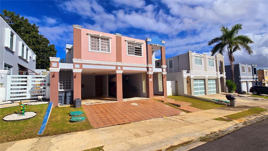 A two-story house with a tiled carport and a palm tree in the front yard — Italia URB. PLAZA DE LA FUENTE UNIT 1010, TOA ALTA, PR