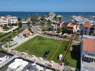 An aerial view shows a vacant waterfront lot with a boat dock and surrounding residential buildings — 1 SAN MIGUEL ISLAND UNIT 6, HUMACAO, PR