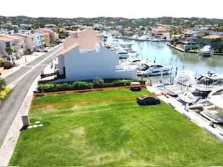 An aerial view shows a vacant grassy waterfront lot next to a marina with boats — 1 SAN MIGUEL ISLAND UNIT 6, HUMACAO, PR