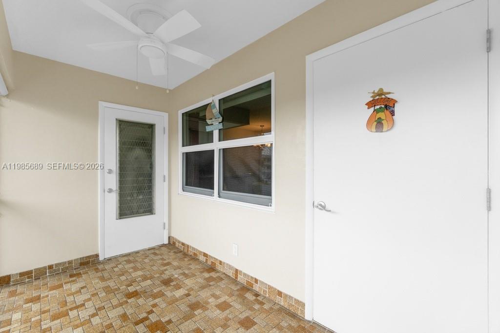 A covered patio features a tiled floor, a ceiling fan, and two white doors — 5300 Washington St # J218, Hollywood FL 33021, HOLLYWOOD, FL