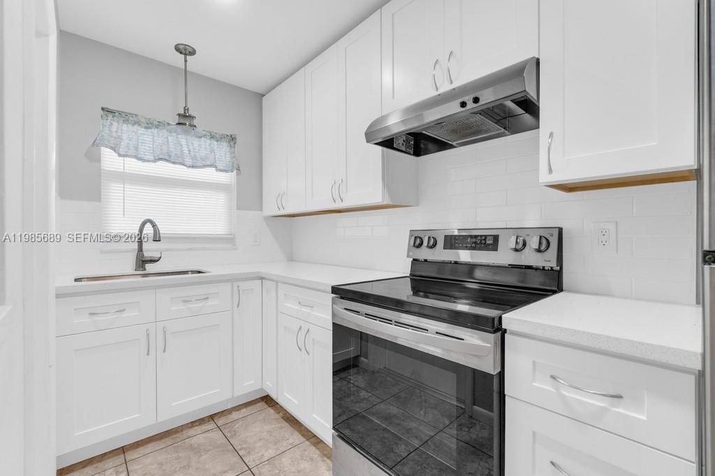 A kitchen features white cabinets, a stainless steel range, and a window above the sink — 5300 Washington St # J218, Hollywood FL 33021, HOLLYWOOD, FL
