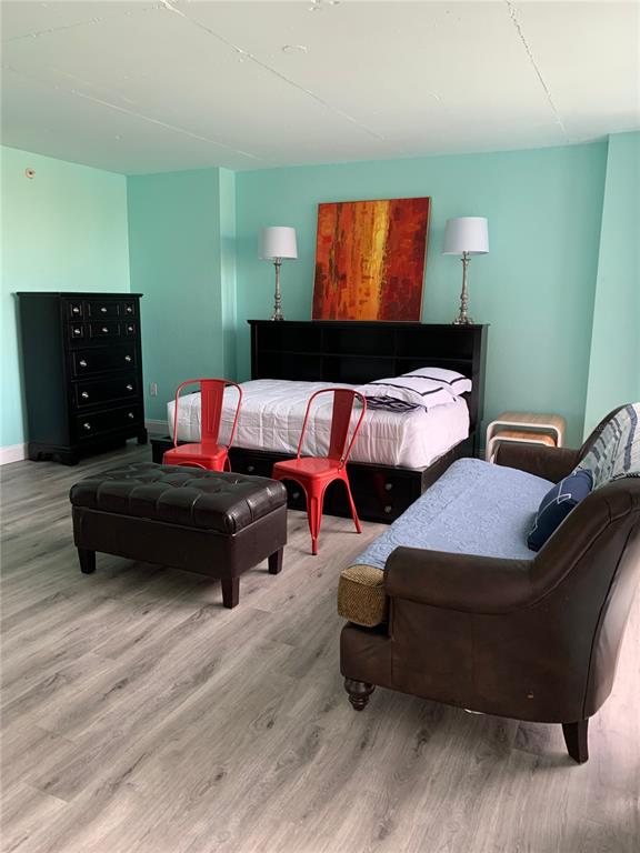 A bedroom features light blue walls, a dark wood bed frame, and a leather armchair — 470 3RD STREET S UNIT 616, ST PETERSBURG, FL