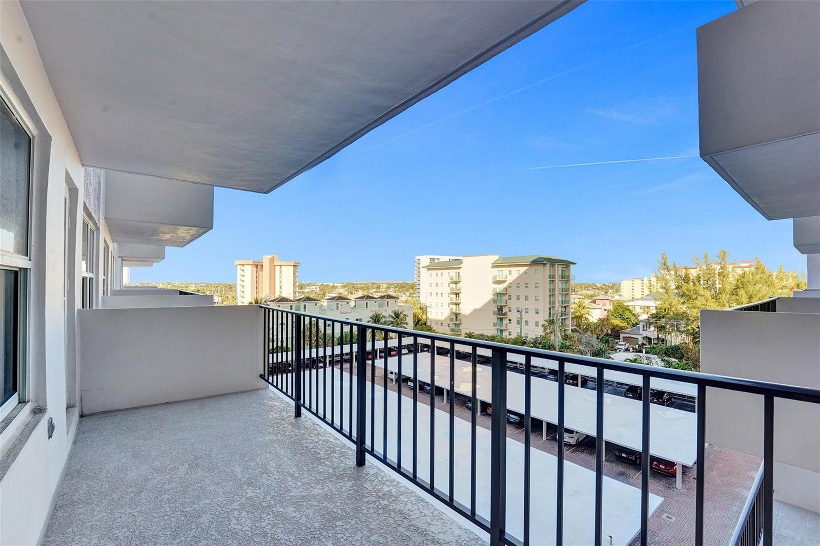A balcony with a metal railing overlooks a parking lot and surrounding apartment buildings — 405 N Ocean Boulevard # 623, Pompano Beach FL 33062, POMPANO BEACH, FL