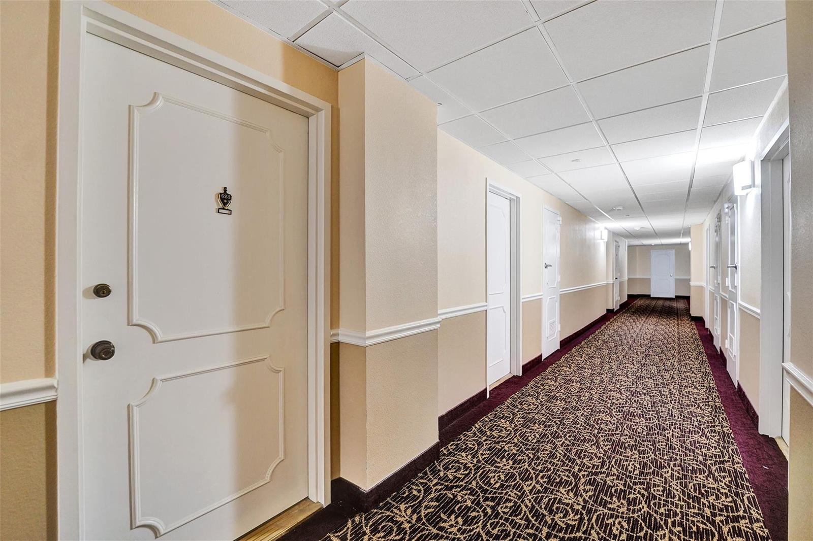 A long hotel hallway features patterned carpet, beige walls, and white doors — 405 N Ocean Boulevard # 623, Pompano Beach FL 33062, POMPANO BEACH, FL