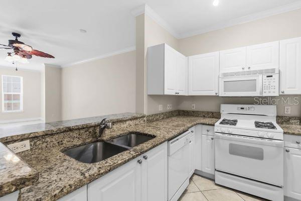 A kitchen with white cabinets, granite countertops, a double sink, and white appliances — 2755 VIA CAPRI UNIT 1225, CLEARWATER, FL