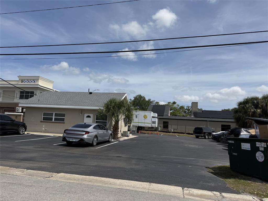 A parking lot sits in front of a single-story building with a white door — 1240 ROGERS STREET, CLEARWATER, FL