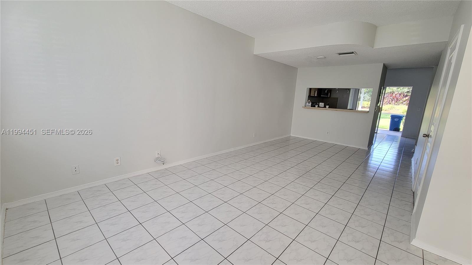 A kitchen features light wood cabinets, stainless steel appliances, and a light-colored countertop — 16731 Hemingway Dr, Weston FL 33326, WESTON, FL