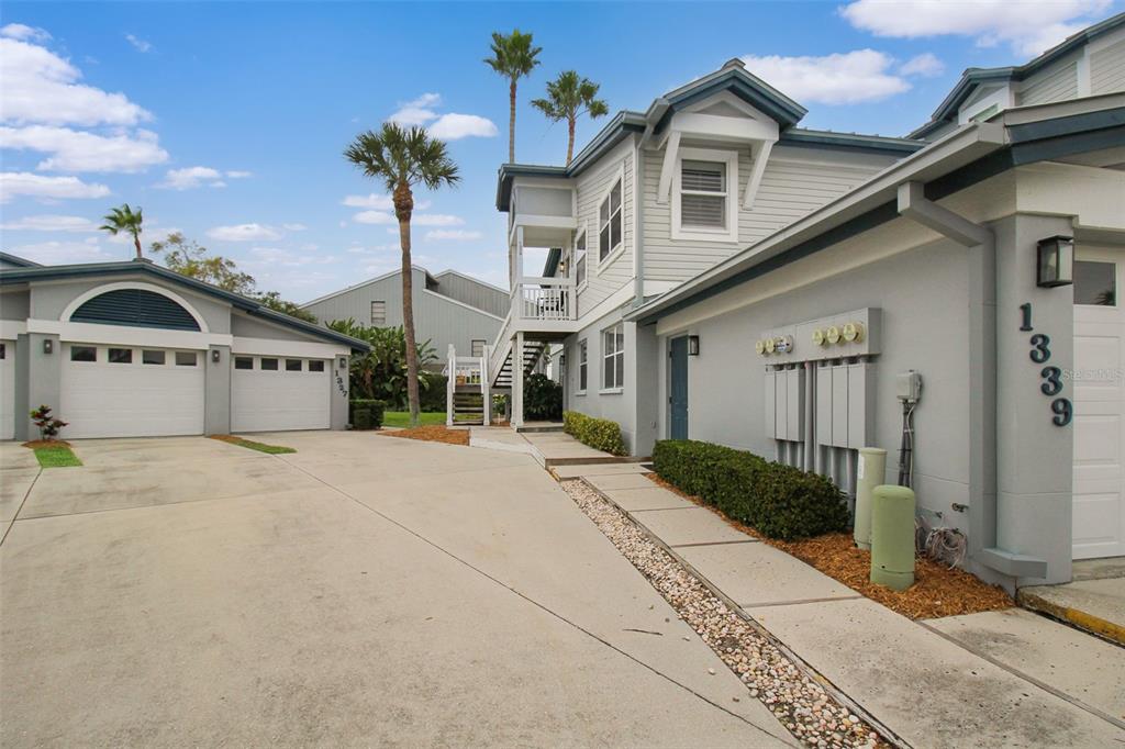 A two-story residential building with a concrete driveway, garage, and exterior utility meters — 1339 SIESTA BAYSIDE DRIVE UNIT 1339-C, SARASOTA, FL
