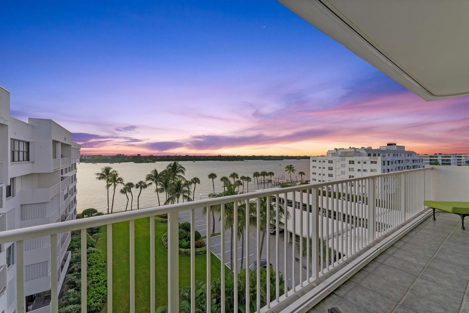 A balcony with a white railing overlooks a waterfront view at sunset — 2860 S Ocean Boulevard # 601, Palm Beach FL 33480, PALM BEACH, FL