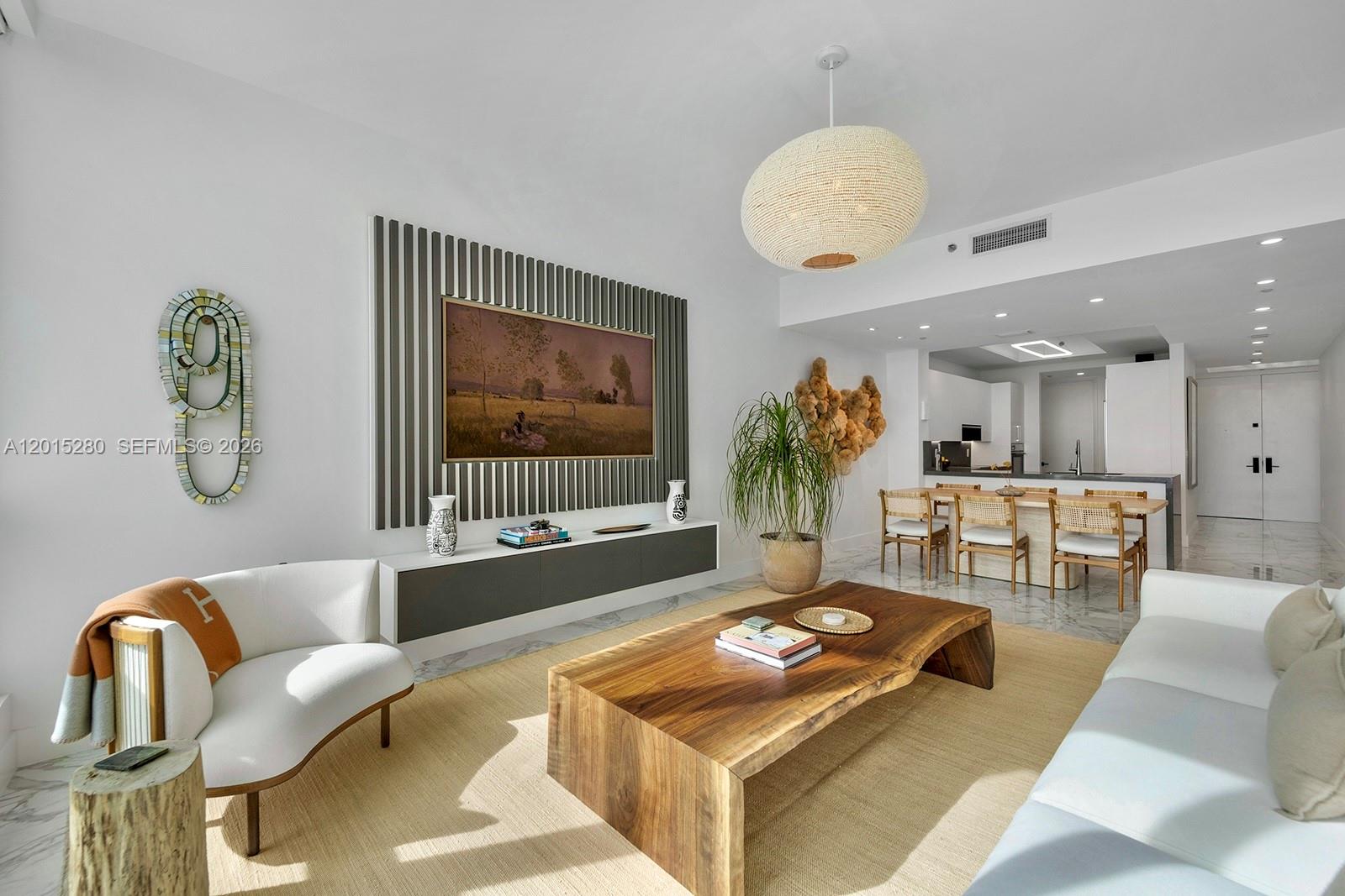 A living room features a live-edge wooden coffee table, a slatted wall, and white furniture — 100 S Pointe Dr # 2003, Miami Beach FL 33139, MIAMI BEACH, FL